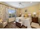 Inviting bedroom with a ceiling fan, wood floors, and a large window with a view of the outdoors at 12019 Sawgrass Lake Ter, Bradenton, FL 34211