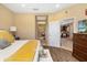 Bedroom showcasing wood floors, bathroom access and an open doorway leading to the kitchen at 12019 Sawgrass Lake Ter, Bradenton, FL 34211