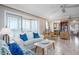 Bright living room with tiled floors, a white sofa with blue pillows, and balcony access showcasing ocean views at 1255 Tarpon Center Dr # 315, Venice, FL 34285