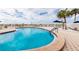 Community pool area with clear blue water, a safety fence, and palm trees at 1255 Tarpon Center Dr # 315, Venice, FL 34285