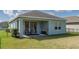 A covered back patio featuring two chairs and a sliding glass door to the home at 13540 Old Creek Ct, Parrish, FL 34219