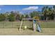 A wooden playset is featured in the backyard, complete with swings and a slide at 13540 Old Creek Ct, Parrish, FL 34219