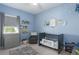Serene Bedroom features a blue accent wall with star decals, a gray crib, and a comfortable glider chair at 13540 Old Creek Ct, Parrish, FL 34219
