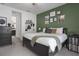 Green bedroom featuring a queen-sized bed, a dresser, a view to the en-suite bathroom, and gallery wall at 13540 Old Creek Ct, Parrish, FL 34219