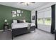 Comfortable bedroom features a green accent wall, a queen-sized bed, and a window with natural light at 13540 Old Creek Ct, Parrish, FL 34219