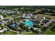 Aerial view of a luxurious community pool with lush landscaping, cabanas, and ample seating areas at 13540 Old Creek Ct, Parrish, FL 34219