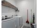 Functional laundry room features a modern washer and dryer, wire shelving, and ample storage space at 13540 Old Creek Ct, Parrish, FL 34219