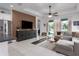 Open-concept living space with tile flooring, a modern media console, and backyard access at 13540 Old Creek Ct, Parrish, FL 34219