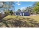Spacious backyard featuring a disc golf basket, a small patio set and a blue outbuilding at 1367 21St St, Sarasota, FL 34234
