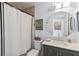 Cozy bathroom featuring a shower/tub with decorative curtain and round mirror over the vanity at 1367 21St St, Sarasota, FL 34234