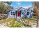 Charming blue home featuring a bright red front door, manicured landscaping, and large, bright windows at 1367 21St St, Sarasota, FL 34234