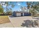 Side view of a blue home with a large, paved driveway leading to an attached garage at 1367 21St St, Sarasota, FL 34234