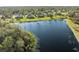 Aerial view of homes bordering a serene lake, showcasing lush landscaping and the neighborhood's tranquil waterfront living at 14730 1St E Ave, Bradenton, FL 34212