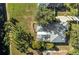 Aerial view of a home with a screened-in patio, pool, lush landscaping, and a serene backyard at 14730 1St E Ave, Bradenton, FL 34212