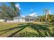 Spacious backyard featuring a screened-in lanai, white fence, and lush green lawn at 14730 1St E Ave, Bradenton, FL 34212