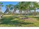 A backyard features a cozy fire pit with benches, surrounded by shade trees and providing a relaxing outdoor gathering spot at 14730 1St E Ave, Bradenton, FL 34212