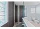 This modern shower has gray tiling, a glass enclosure, and a glass-block window at 14730 1St E Ave, Bradenton, FL 34212