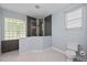 Well-lit bathroom showcases glass-block window and glass shower with gray and white mosaic tile at 14730 1St E Ave, Bradenton, FL 34212