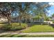 Well-maintained exterior with lush landscaping, mature trees, and a green lawn at 14730 1St E Ave, Bradenton, FL 34212