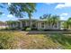 Charming single story home featuring arched windows, gray stucco, and mature landscaping at 14730 1St E Ave, Bradenton, FL 34212