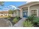 Inviting front entrance featuring a vibrant blue door, lush landscaping, and a well-maintained walkway at 14730 1St E Ave, Bradenton, FL 34212