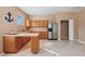 Kitchen with cabinetry and countertops, a stainless-steel refrigerator, and a doorway at 14730 1St E Ave, Bradenton, FL 34212