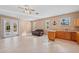 A spacious living room with a kitchen area, lounge furniture, and outdoor access at 14730 1St E Ave, Bradenton, FL 34212
