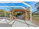 Covered patio features cozy wicker furniture, perfect for enjoying the lush green surroundings and a relaxing outdoor living space at 14730 1St E Ave, Bradenton, FL 34212