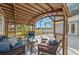Outdoor wooden patio with comfortable wicker furniture overlooking the backyard's serene lake view, creating an ideal relaxation spot at 14730 1St E Ave, Bradenton, FL 34212