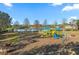 Community playground featuring swings, slides, and a covered picnic area near the lake at 14730 1St E Ave, Bradenton, FL 34212