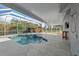 Relaxing enclosed lanai with a beautiful pool, waterfall feature, and a shaded seating area at 14730 1St E Ave, Bradenton, FL 34212