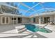 A screened-in pool area boasts a pristine pool, patio seating, and a seamless blend of indoor-outdoor living at 14730 1St E Ave, Bradenton, FL 34212