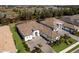 Aerial view of a luxurious home with a brick driveway, lush landscaping, and a three-car garage at 14803 Derna Ter, Bradenton, FL 34211