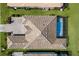 Aerial view of a home with a tile roof, pool, backyard, and brick driveway at 14803 Derna Ter, Bradenton, FL 34211