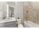 Stylish bathroom featuring a tub-shower combination with a tiled backsplash, marble countertops, and a view to a bedroom at 14803 Derna Ter, Bradenton, FL 34211