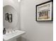 Elegant half-bathroom featuring a pedestal sink, round mirror, and stylish wall decor at 14803 Derna Ter, Bradenton, FL 34211