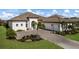 Stunning single-Gathering home featuring a lush lawn, tile roof, and brick-paved driveway leading to a three-car garage at 14803 Derna Ter, Bradenton, FL 34211