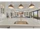 Open gourmet kitchen with island, sink and stainless appliances flows into living area at 14803 Derna Ter, Bradenton, FL 34211