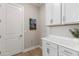 Cozy laundry room featuring white shaker cabinets, laminate flooring, and plenty of counter space at 14803 Derna Ter, Bradenton, FL 34211