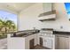 Outdoor kitchen with built in stainless grill, granite countertops and palm tree view at 14803 Derna Ter, Bradenton, FL 34211