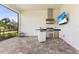 Stylish outdoor kitchen featuring a built-in grill, sink, and modern stainless steel appliances at 14803 Derna Ter, Bradenton, FL 34211