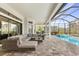 Inviting outdoor living area with comfortable seating, a screened pool, and lush landscaping at 14803 Derna Ter, Bradenton, FL 34211