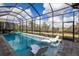 Screened-in pool with jacuzzi and lounge chairs surrounded by brick and view at 14803 Derna Ter, Bradenton, FL 34211