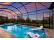 Relaxing screened-in pool area with two lounge chairs and spa offering a picturesque sunset view at 14803 Derna Ter, Bradenton, FL 34211
