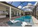 Screened-in pool area with clear blue water, jacuzzi, and outdoor lounge chairs at 14803 Derna Ter, Bradenton, FL 34211