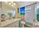 Bright bathroom with a shower-tub combination, soft turquoise accents, and beach-themed decor at 1620 Fairway Trce # B, Palmetto, FL 34221