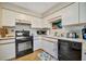 Well-maintained kitchen with white cabinets, black appliances, and tile flooring at 1620 Fairway Trce # B, Palmetto, FL 34221