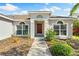 Well-maintained home entrance with colorful garden beds and a brick-red front door at 209 111Th E St, Bradenton, FL 34212