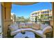 Balcony with comfortable seating offering views of the surrounding buildings, palm trees, and blue sky at 2141 Gulf Of Mexico Dr Unit # 4, Longboat Key, FL 34228