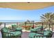 Spacious balcony with multiple chairs overlooking the ocean, beach, and palm trees at 2141 Gulf Of Mexico Dr Unit # 4, Longboat Key, FL 34228